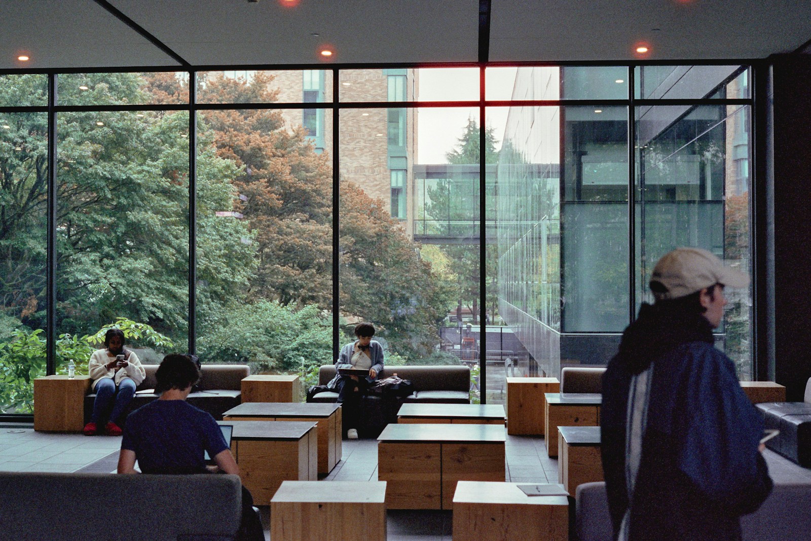 a group of people sitting in a room with large windows